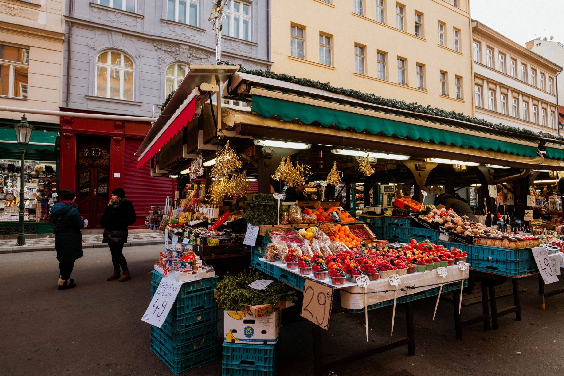 Obst- und Gemüsestand unter Markisen auf einem Platz in der Stadt