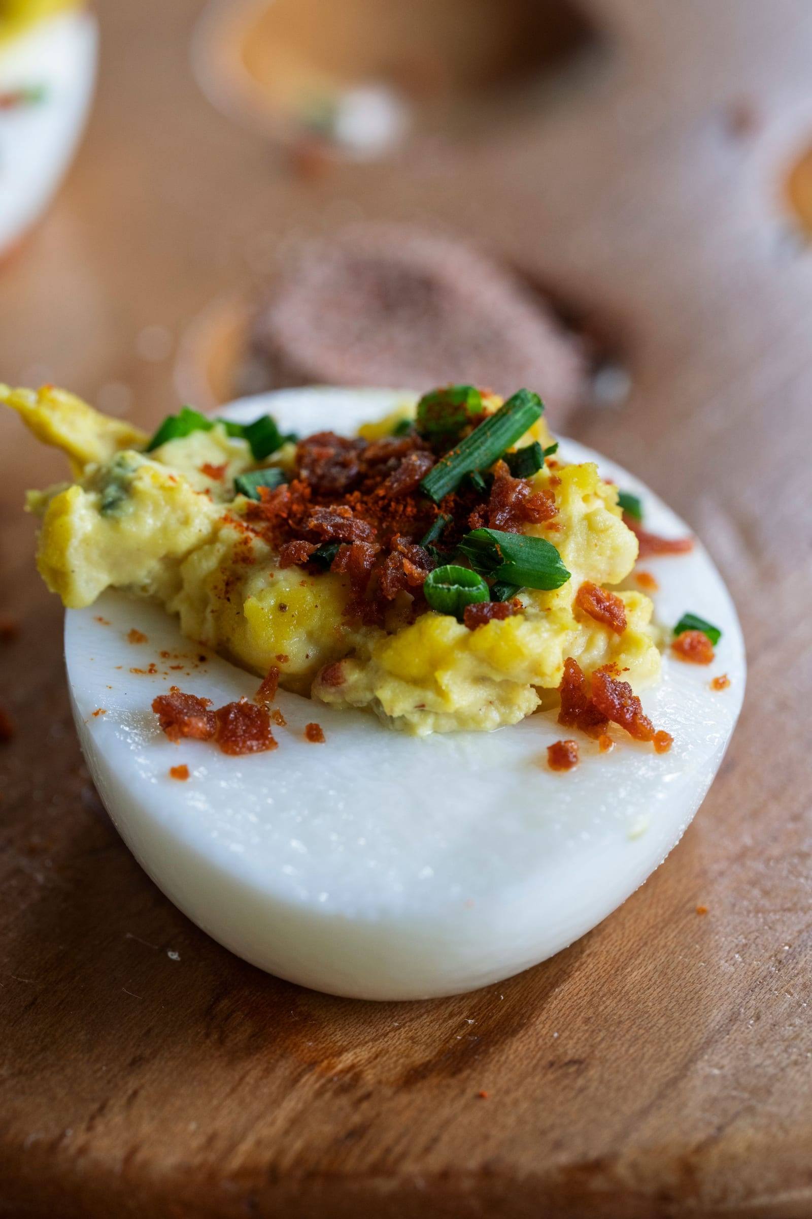 Gefülltes Ei mit Schnittlauch und Paprika auf einem Holzbrett